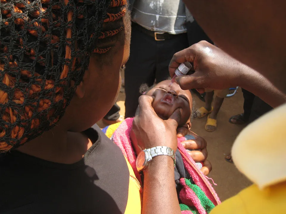 A young child receives an oral vaccine dose during an immunization campaign.