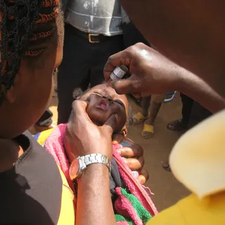 A young child receives an oral vaccine dose during an immunization campaign.